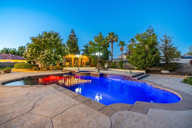 pool at dusk featuring a patio area