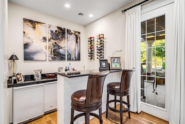 bar featuring light hardwood / wood-style floors