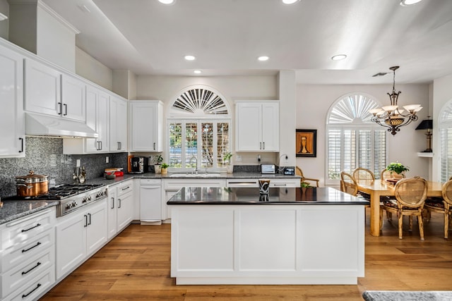 kitchen featuring pendant lighting, white cabinetry, stainless steel gas stovetop, and sink