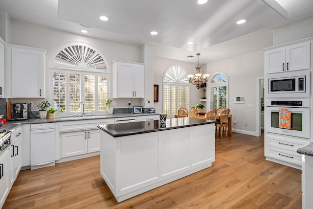 kitchen featuring white cabinets, oven, and a chandelier