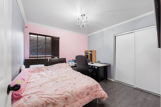 bedroom with a closet, dark hardwood / wood-style flooring, crown molding, and a notable chandelier