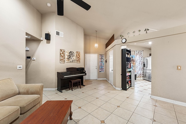 tiled living room with ceiling fan and high vaulted ceiling