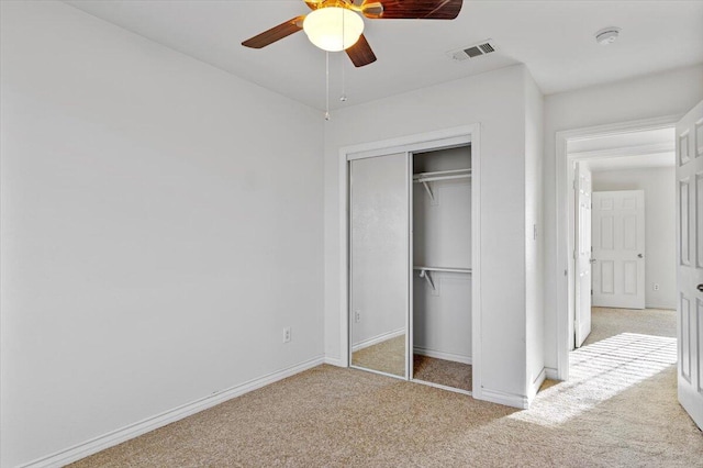 unfurnished bedroom with light carpet, baseboards, visible vents, and a closet