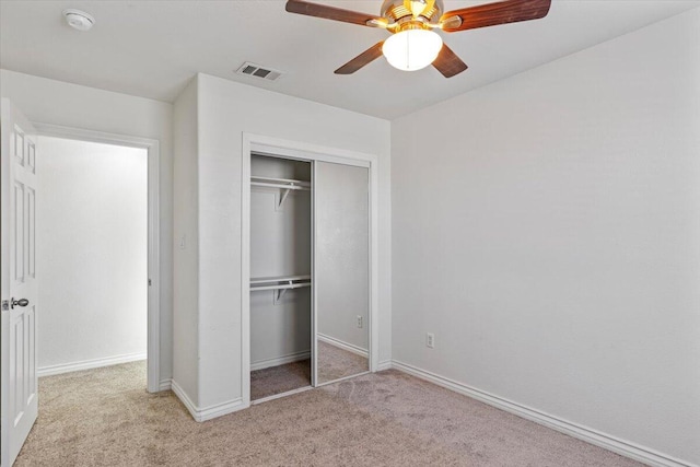 unfurnished bedroom featuring carpet, a closet, visible vents, ceiling fan, and baseboards