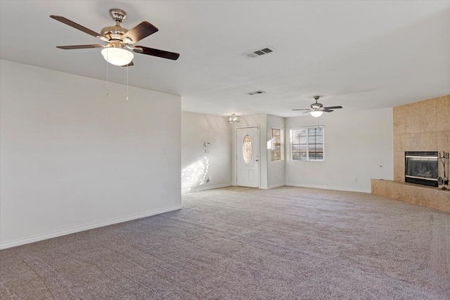 unfurnished living room featuring light carpet, a tile fireplace, visible vents, and baseboards