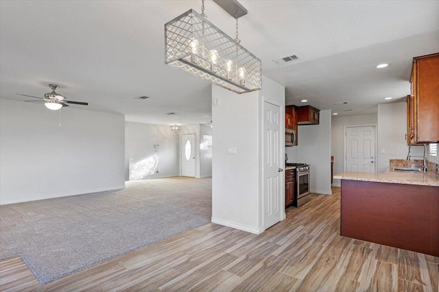 kitchen featuring light carpet, stainless steel appliances, a sink, visible vents, and open floor plan