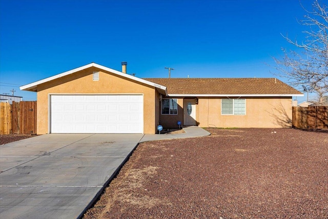 single story home featuring a garage, fence, driveway, and stucco siding