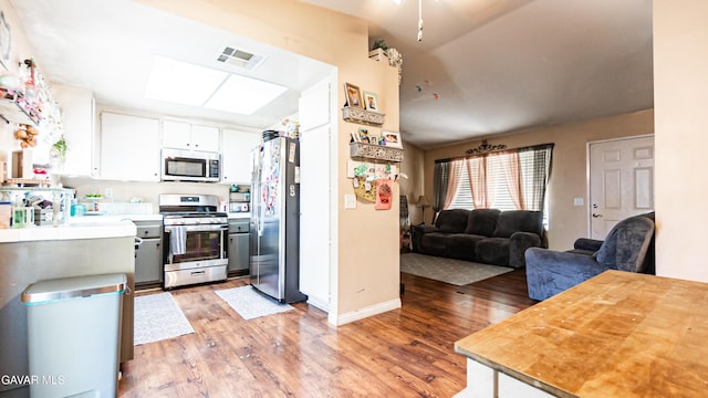 2839 Minford St, Lancaster, CA 93536 - kitchen with appliances with stainless steel finishes, light wood-type flooring, open floor plan, and light countertops