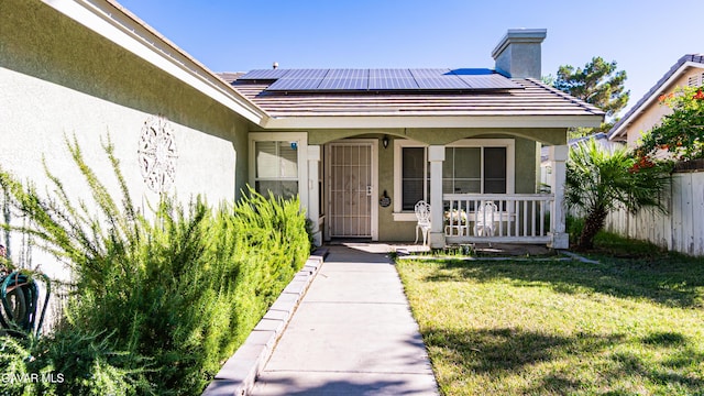 2839 Minford St, Lancaster, CA 93536 - doorway to property featuring a porch, stucco siding, roof mounted solar panels, and a chimney