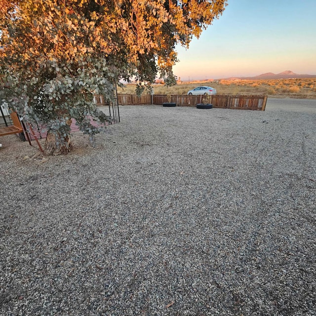 yard at dusk featuring a mountain view