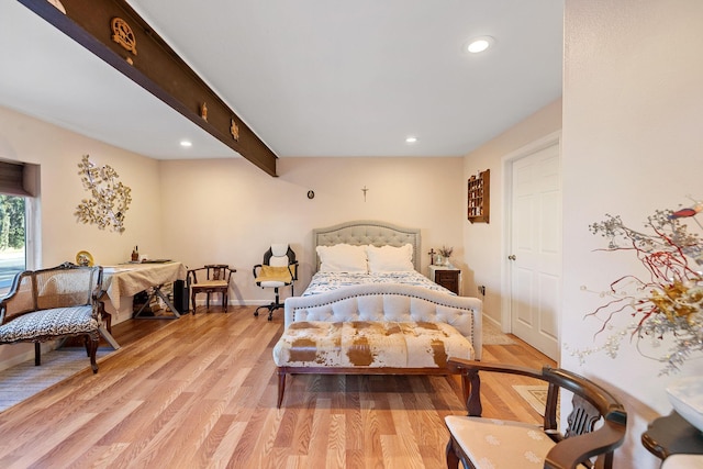 bedroom featuring beam ceiling and light hardwood / wood-style flooring