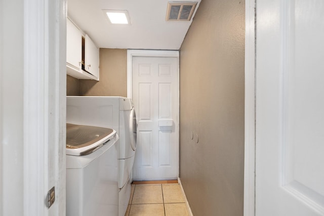 laundry area featuring cabinets, independent washer and dryer, and light tile patterned floors