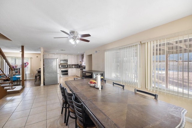 dining space featuring ceiling fan and light tile patterned floors