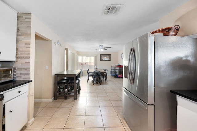 44627 E 11th St, Lancaster, CA 93535 - kitchen with stainless steel refrigerator with ice dispenser, ceiling fan, dark countertops, white cabinetry, and light tile patterned flooring