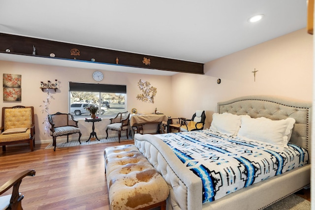 bedroom featuring wood-type flooring and beam ceiling