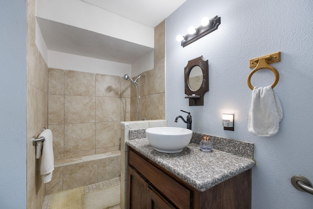 bathroom featuring vanity and tiled shower