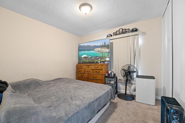 carpeted bedroom featuring radiator heating unit and a textured ceiling