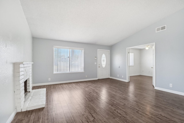unfurnished living room featuring a fireplace, visible vents, lofted ceiling, and dark wood-type flooring