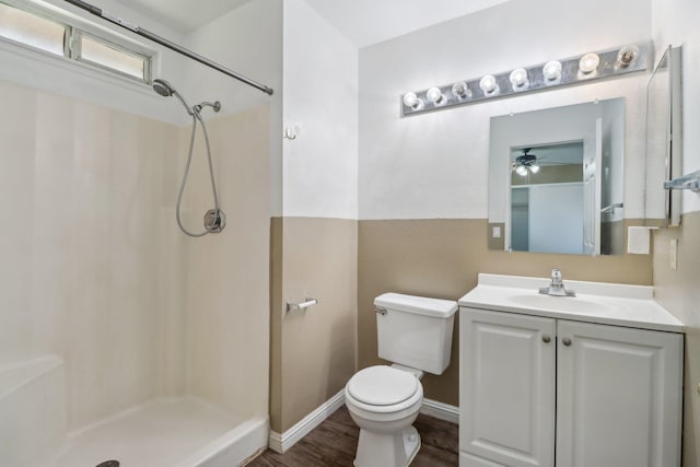 bathroom featuring ceiling fan, a shower stall, wood finished floors, vanity, and toilet