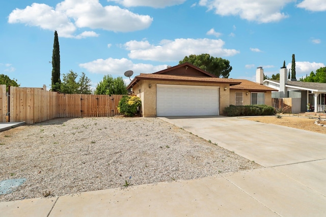 ranch-style house with fence, an attached garage, stucco siding, a gate, and concrete driveway