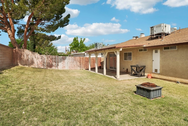 view of yard featuring cooling unit, a fenced backyard, a patio area, and an outdoor fire pit