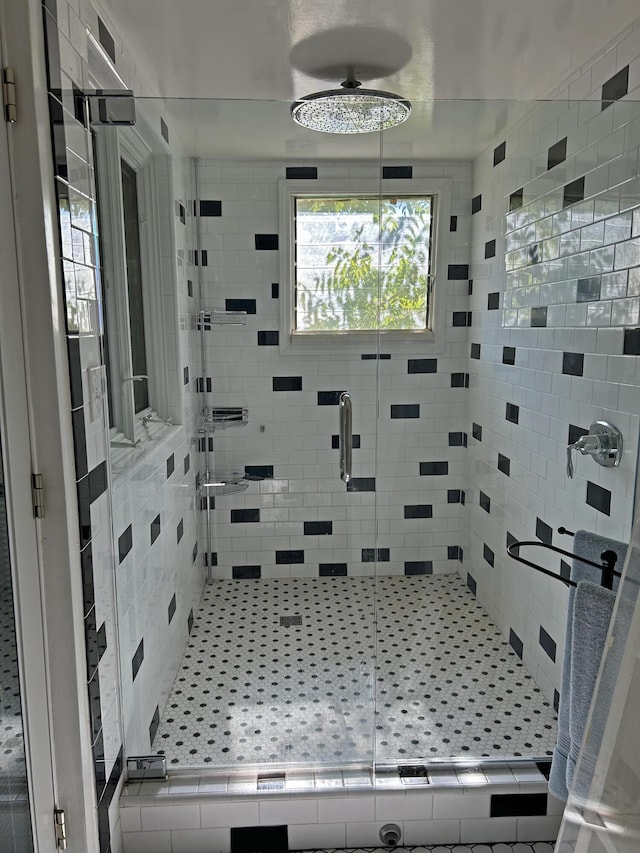 bathroom with ceiling fan and a shower with shower door