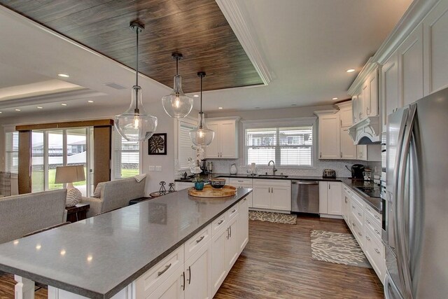 3047 Lou St, Hilo, HI 96720 - kitchen featuring appliances with stainless steel finishes, dark wood-style flooring, a center island, tasteful backsplash, and dark countertops