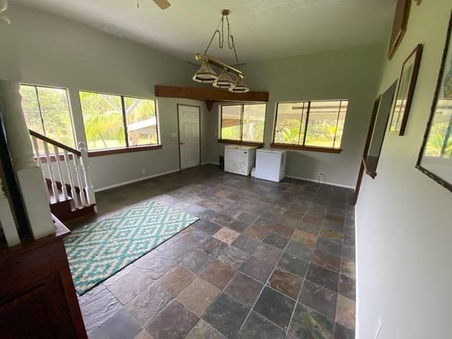 11-3193 Hibiscus St, Mountain View, HI 96771 - unfurnished dining area with baseboards, stone tile floors, and plenty of natural light