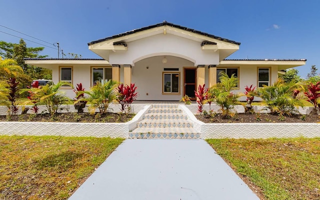 15-1660 3rd Ave, Keaau, HI 96749 - mediterranean / spanish house featuring stucco siding, covered porch, and a front yard