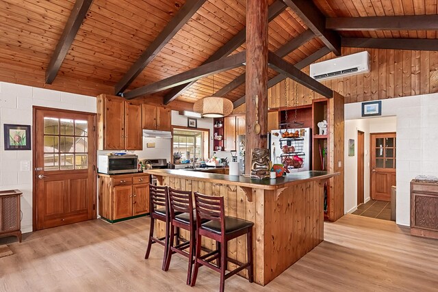 17-8160 N Kulani Rd, Mountain View, HI 96771 - kitchen with a wall unit AC, appliances with stainless steel finishes, brown cabinets, wood ceiling with exposed beams, and light wood-style flooring