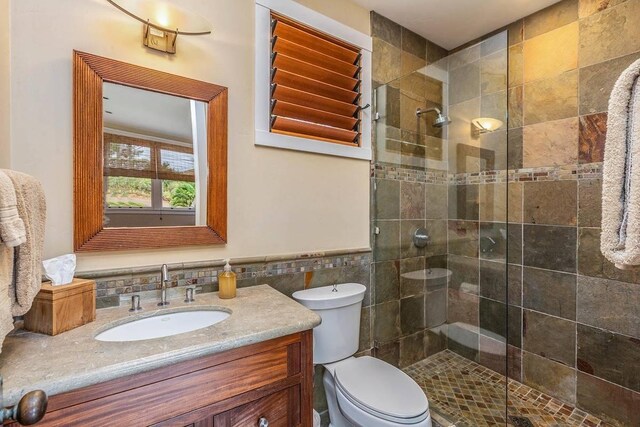 5070 Kukuna Rd, Anahola, HI 96746 - full bathroom with tile walls, vanity, a shower stall, toilet, and wainscoting