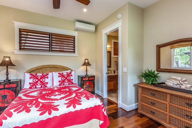 5070 Kukuna Rd, Anahola, HI 96746 - bedroom featuring a wall unit AC, wood finished floors, ensuite bath, baseboards, and recessed lighting