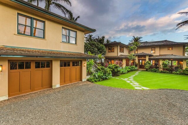 5070 Kukuna Rd, Anahola, HI 96746 - view of front of house with stucco siding, a front lawn, a garage, and driveway