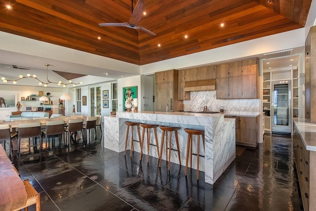 72-3023 Kakapa Pl, Kailua-Kona, HI 96740 - kitchen with brown cabinets, ceiling fan, wooden ceiling, a kitchen bar, and open floor plan