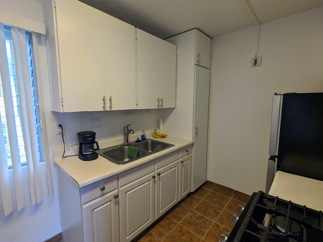74-5618 Palani Rd Unit K4, Kailua-Kona, HI 96740 - kitchen featuring freestanding refrigerator, a sink, light countertops, white cabinets, and dark tile patterned flooring