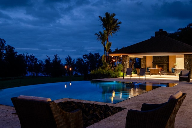 28-3320 Beach Rd, Pepeekeo, HI 96783 - pool at twilight with a patio area, a gazebo, an infinity pool, and exterior fireplace