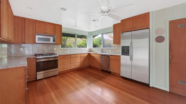 5118 Lawai Rd, Koloa, HI 96756 - kitchen featuring stainless steel appliances, wood finished floors, decorative backsplash, ceiling fan, and a sink