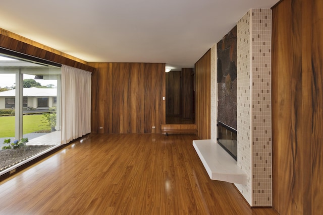 114 Kupaa St, Hilo, HI 96720 - unfurnished living room with wood finished floors, a fireplace, and wooden walls