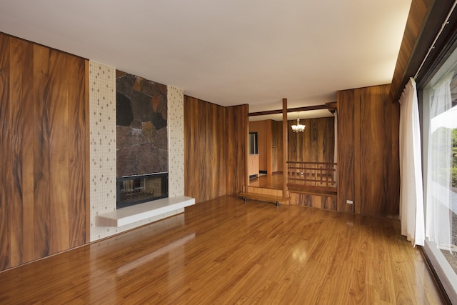 114 Kupaa St, Hilo, HI 96720 - unfurnished living room with a chandelier, wood finished floors, wood walls, and a fireplace