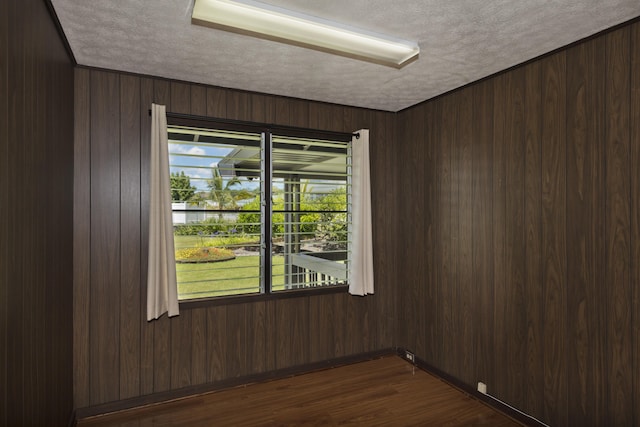 114 Kupaa St, Hilo, HI 96720 - empty room featuring a textured ceiling, wood walls, dark wood finished floors, and baseboards