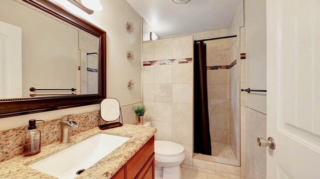 6573-E Puupilo Rd, Kapaa, HI 96746 - bathroom featuring toilet, vanity, tiled shower, and tile patterned flooring