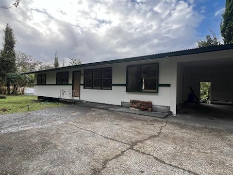 19-4035 Haunani Rd, Volcano, HI 96785 - ranch-style house with driveway and a carport