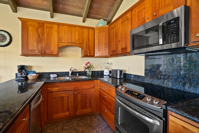 1901 Poipu Rd Unit 632, Koloa, HI 96756 - kitchen featuring stainless steel appliances, a sink, decorative backsplash, dark tile patterned floors, and brown cabinets