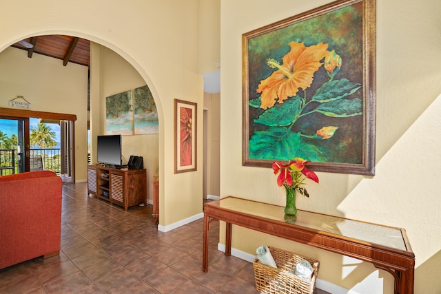 1901 Poipu Rd Unit 632, Koloa, HI 96756 - corridor featuring beam ceiling, arched walkways, a high ceiling, baseboards, and tile patterned flooring