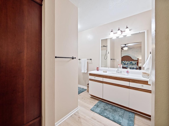 19-4157 Wright Rd, Volcano, HI 96785 - bathroom with vanity, wood finished floors, ensuite bathroom, ceiling fan, and baseboards