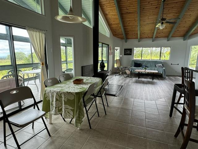17-7860 Kulani Rd, Mountain View, HI 96771 - dining room with wooden ceiling with exposed beams, high vaulted ceiling, dark tile patterned flooring, and a ceiling fan
