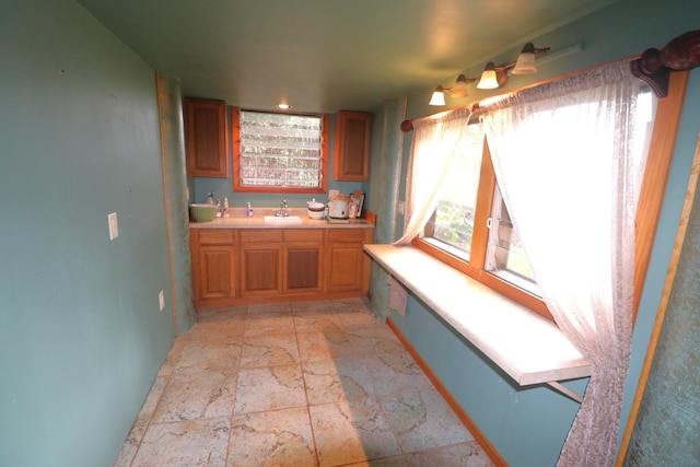 82-6286 Puuhonua Rd, Captain Cook, HI 96704 - kitchen with a sink, baseboards, stone tile flooring, light countertops, and brown cabinets