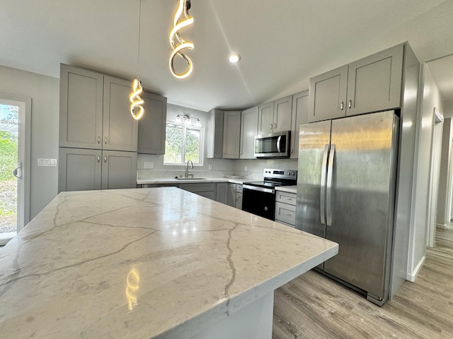 16-2142 Kuhio Dr, Pahoa, HI 96778 - kitchen featuring gray cabinets, stainless steel appliances, light stone countertops, light wood-type flooring, and hanging light fixtures