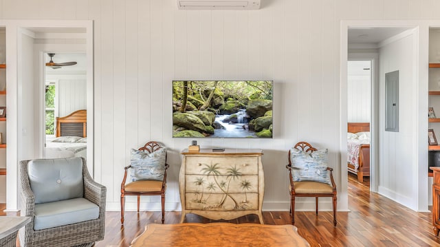1778 Poipu Aina Pl Unit B, Koloa, HI 96756 - living area with hardwood / wood-style floors, a ceiling fan, a wall mounted air conditioner, and electric panel
