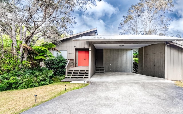 99-7715 Kalehua Pl, Volcano, HI 96778 - view of front of property featuring concrete driveway, metal roof, and a carport